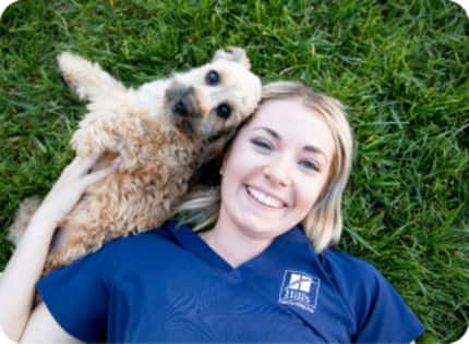 vet nurse on grass playing with a dog